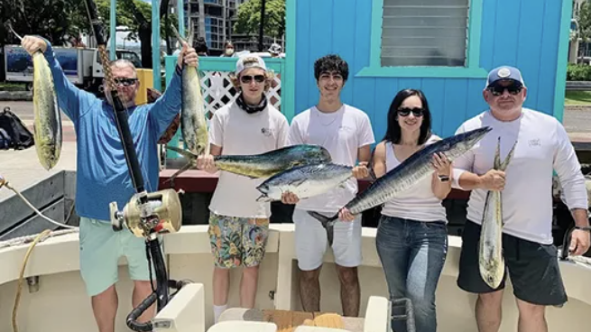 a group of people standing in front of a fish