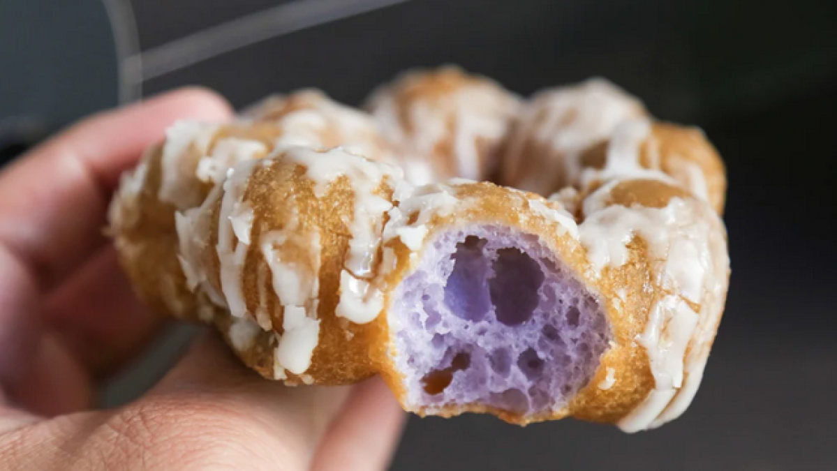 a hand holding a half eaten donut