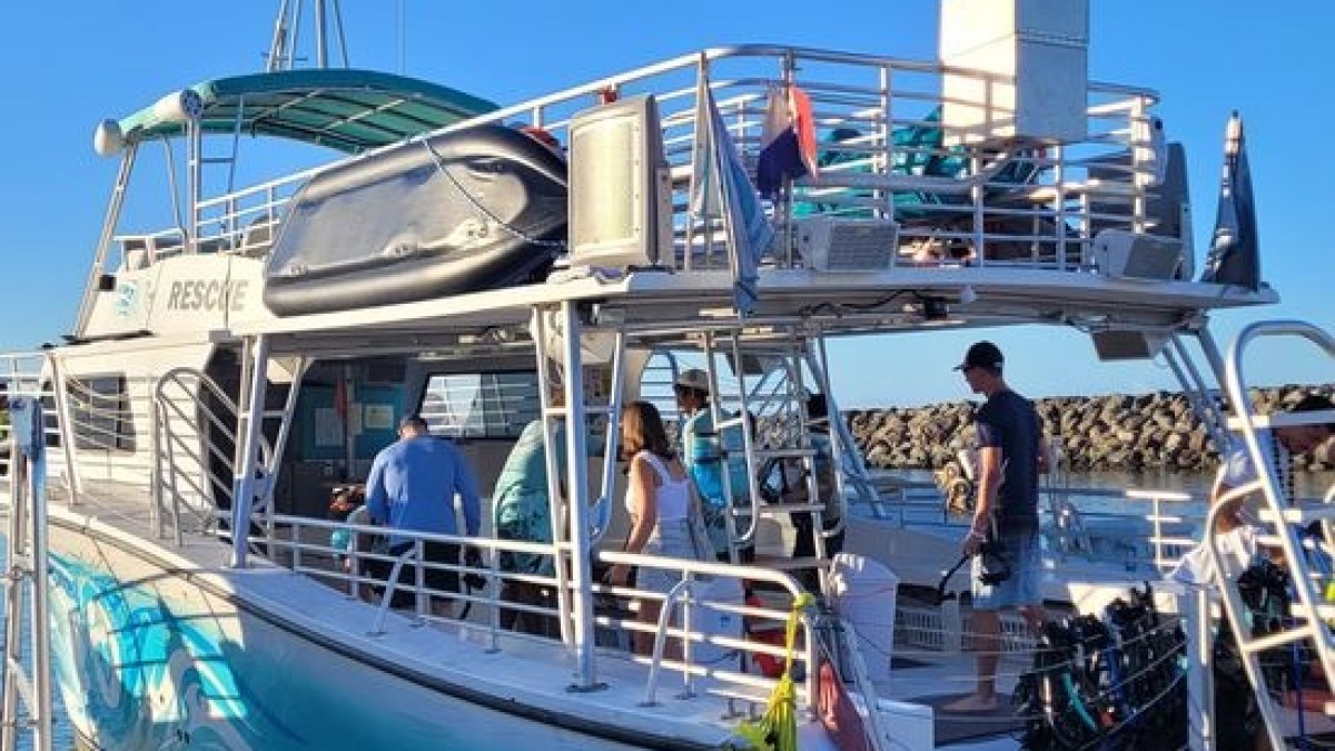 a group of people in a boat docked next to a body of water