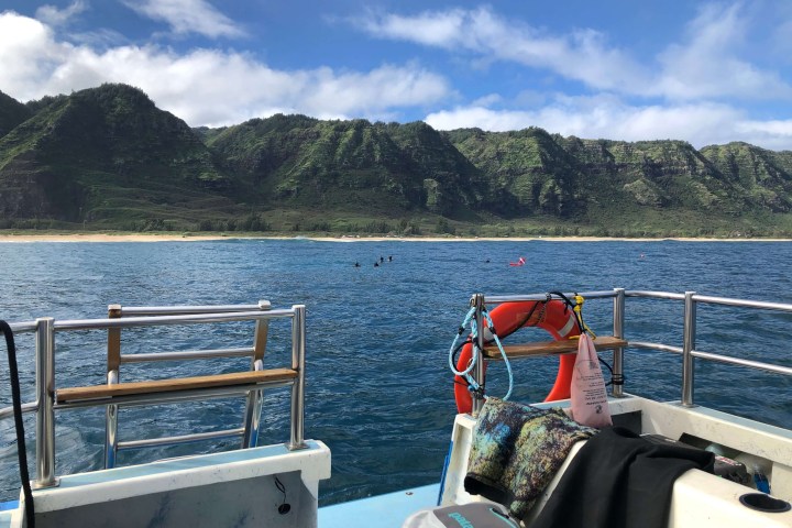 a boat that is sitting on a bench next to a body of water