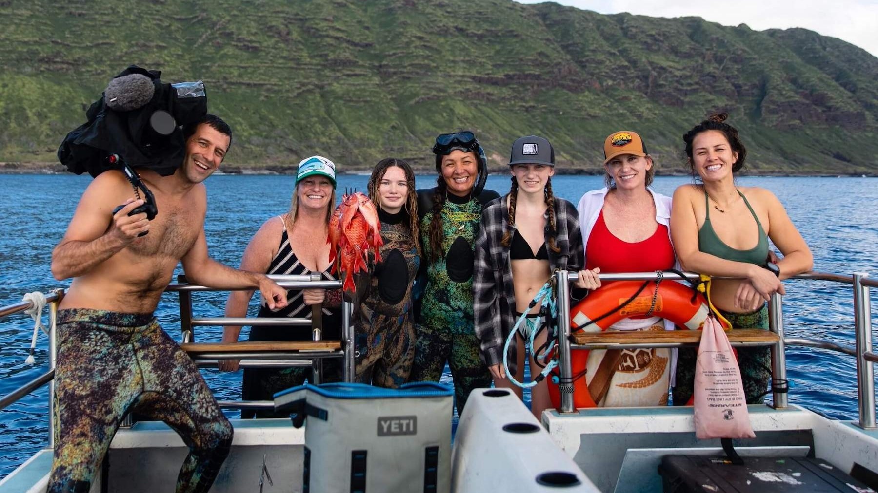 a group of people standing in front of a mountain