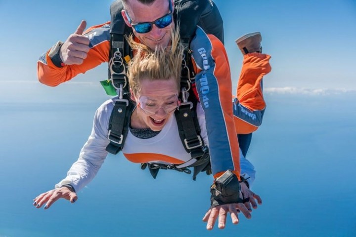 a person flying through the air while swimming in a body of water