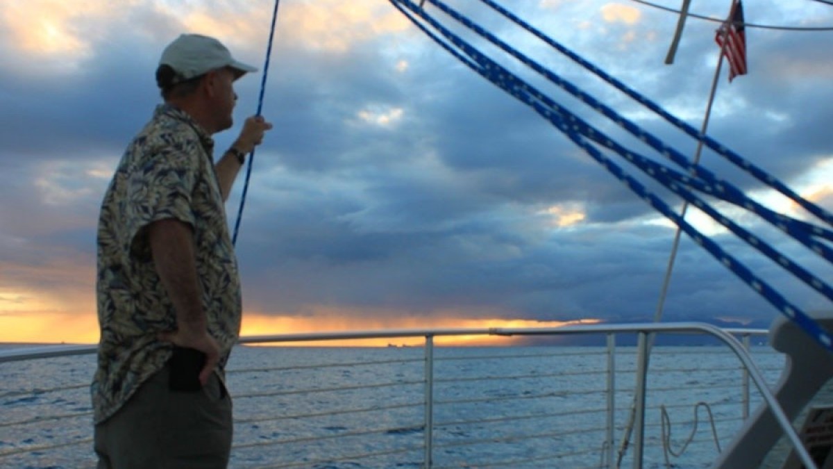a man standing next to a body of water