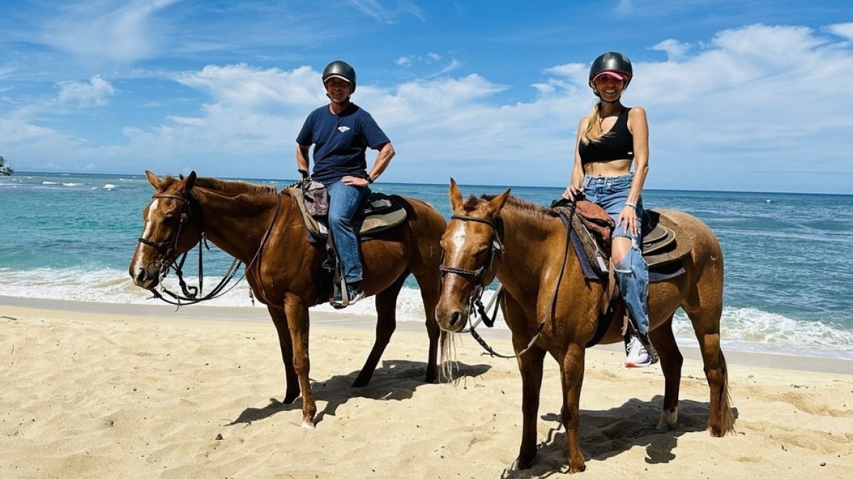 a group of people riding on top of a sandy beach