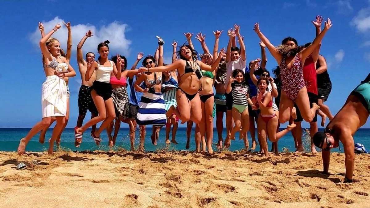 a group of people on a beach posing for the camera