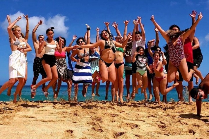 a group of people on a beach posing for the camera