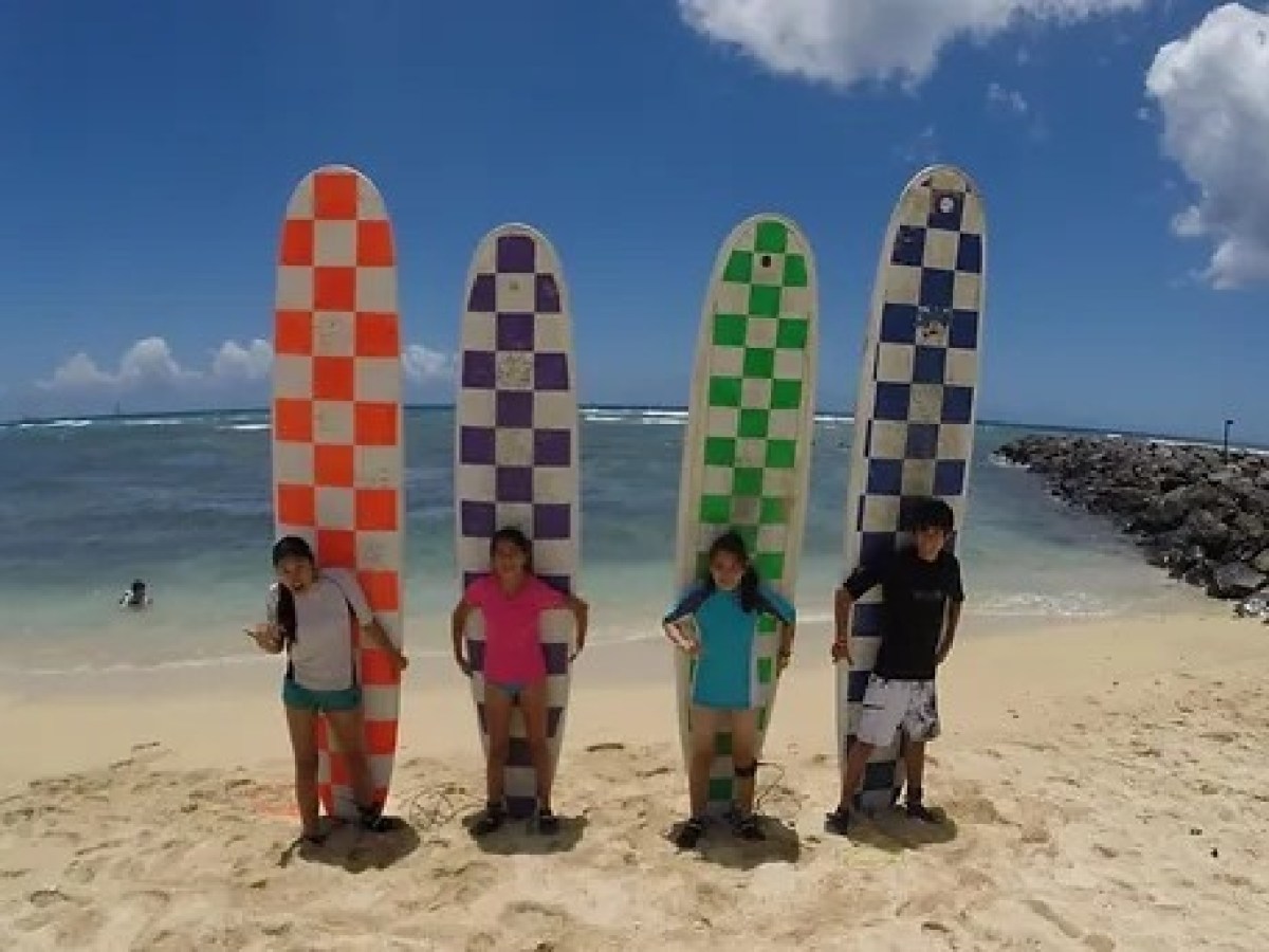 a group of people standing on top of a sandy beach
