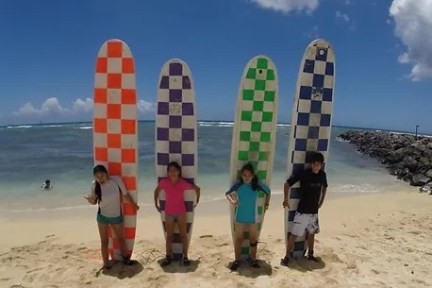 a group of people standing on top of a sandy beach