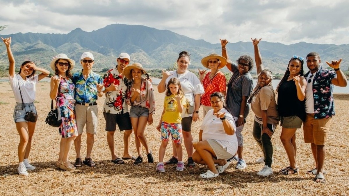a group of people standing on a beach posing for the camera