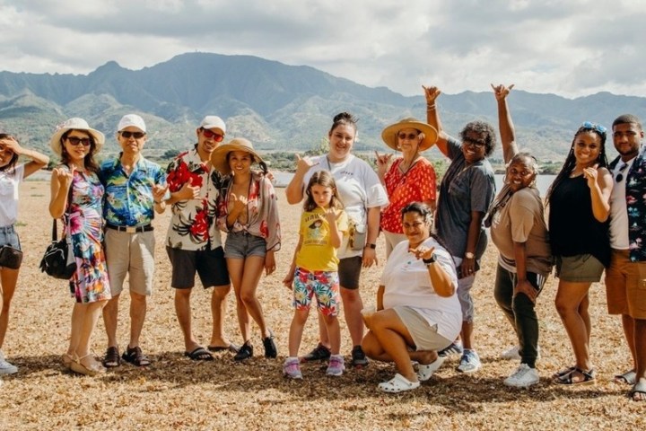 a group of people standing on a beach posing for the camera