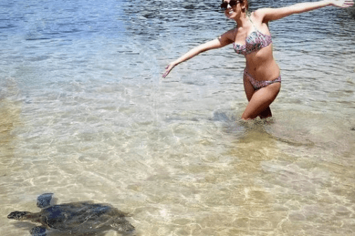 a woman standing next to a body of water