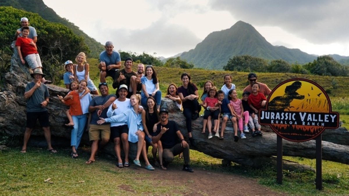 a group of people standing in front of a mountain