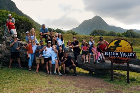 a group of people standing in front of a mountain