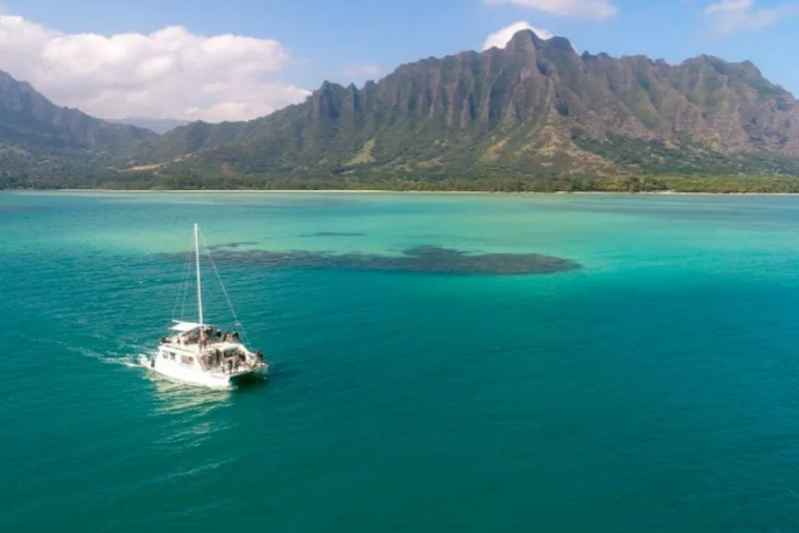 a small boat in a body of water with a mountain in the background