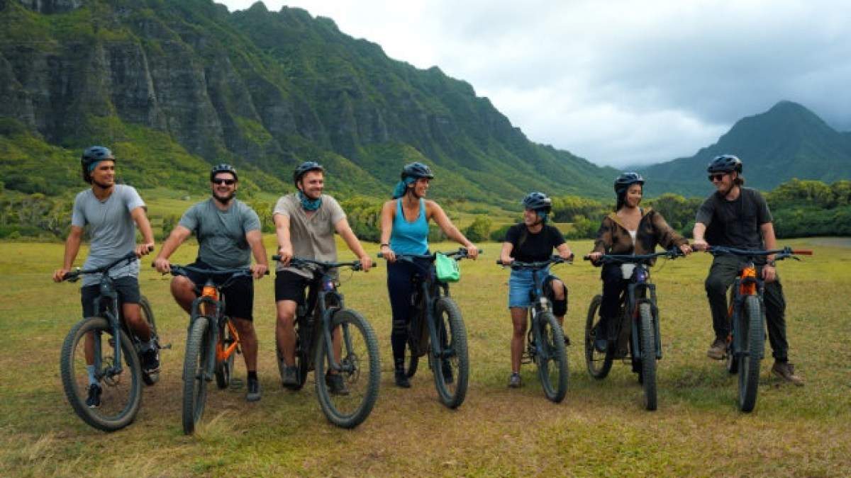 a group of people riding on the back of a bicycle