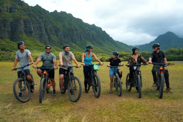 a group of people riding on the back of a bicycle