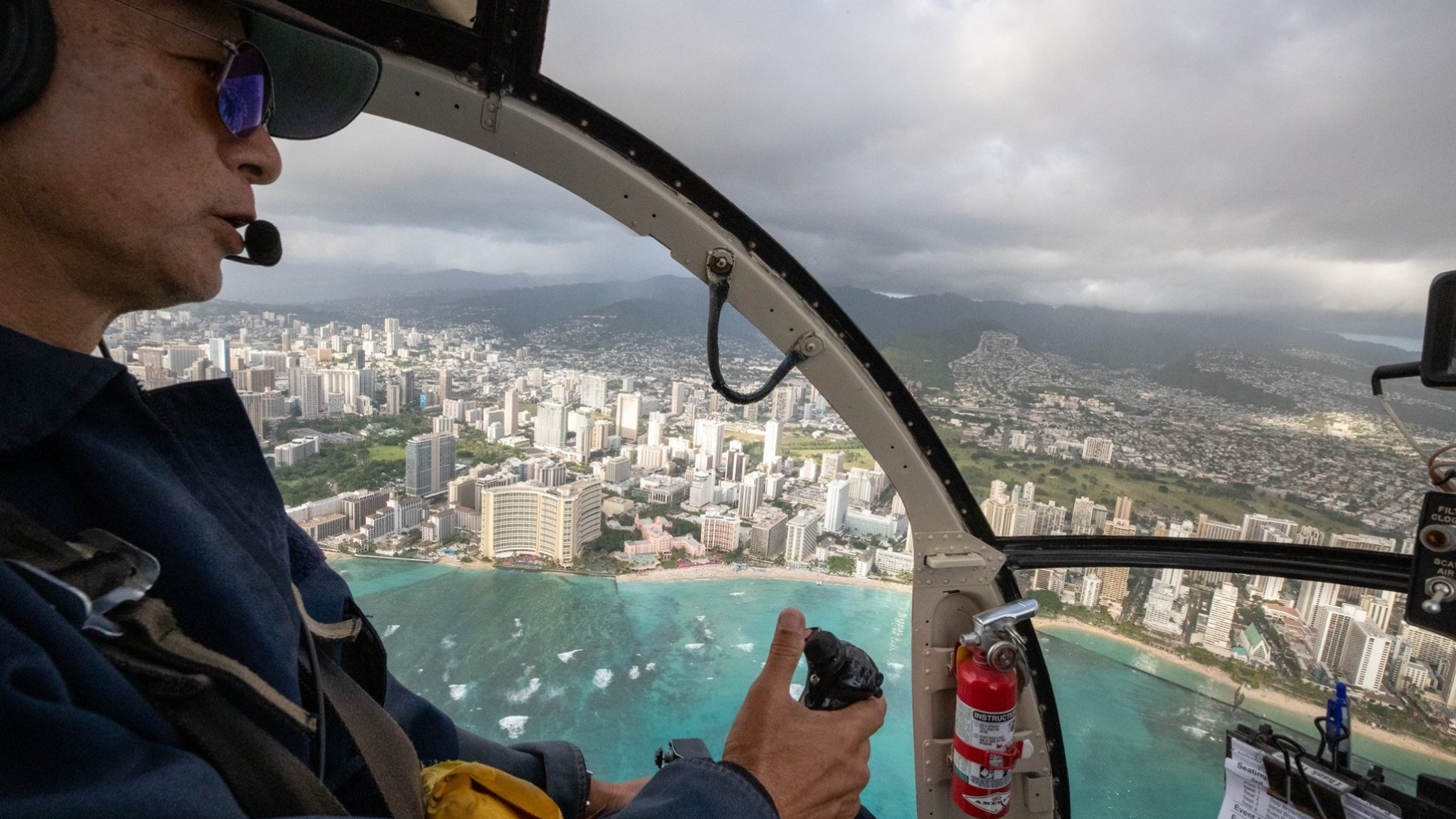 a man wearing sunglasses driving a boat in the water