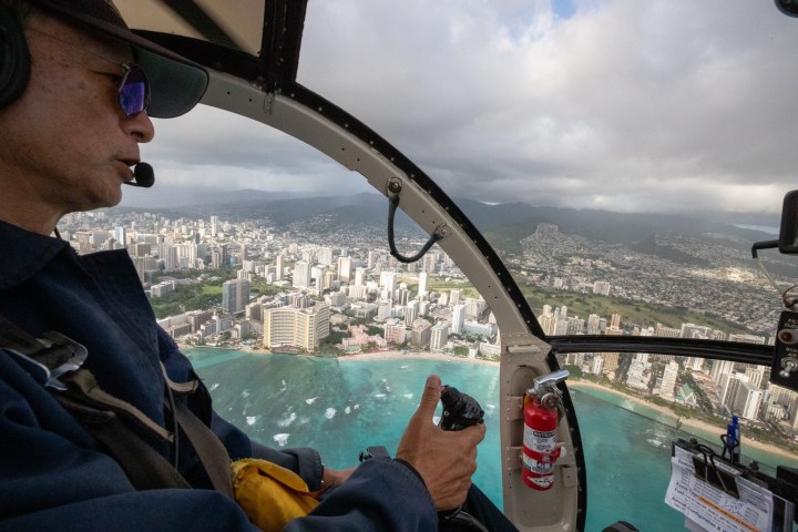 a man wearing sunglasses driving a boat in the water