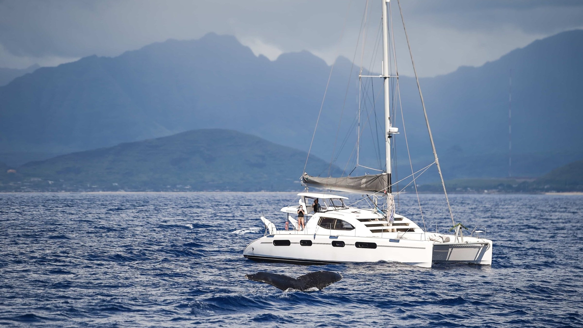 a small boat in a body of water with a mountain in the background
