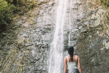 a person standing next to a waterfall