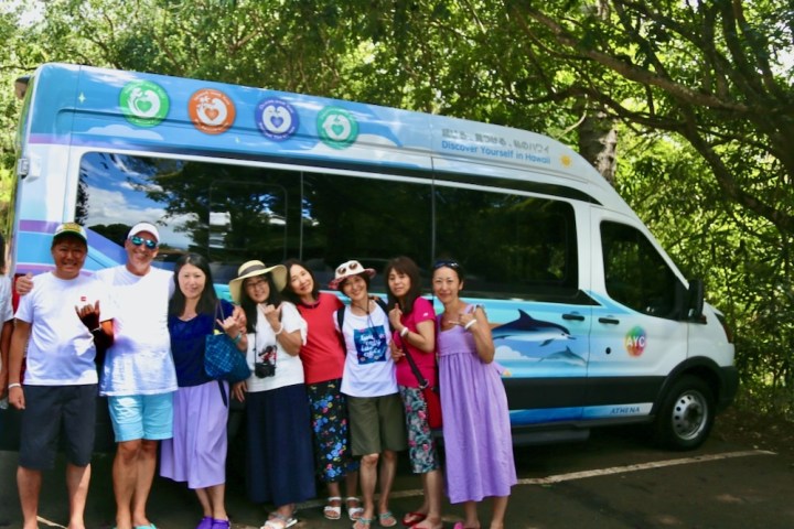 a group of people standing in front of a bus