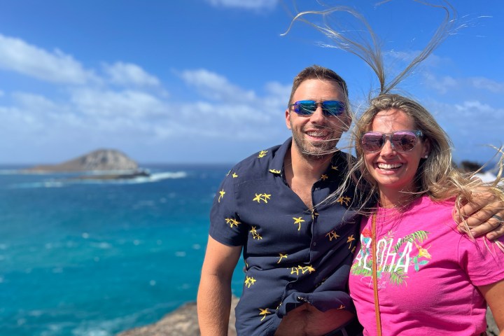 a man and a woman standing next to a body of water