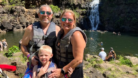 a man holding a child on a rock
