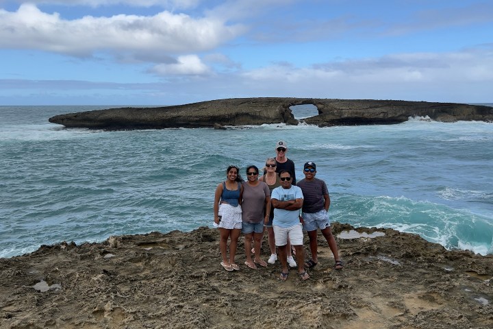 a group of people on a beach near a body of water