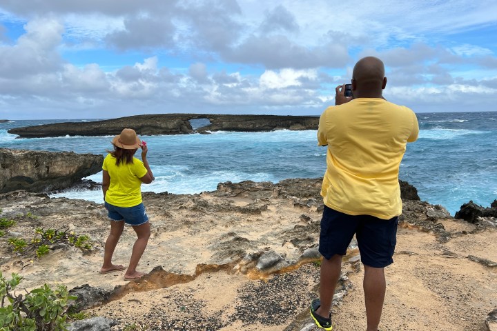 a group of people standing on top of a sandy beach