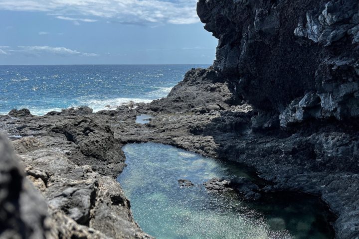 a rocky island in the middle of a body of water