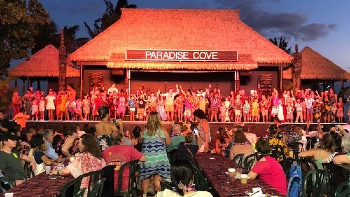 a group of people sitting at a table in front of a building