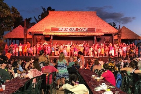 a group of people sitting at a table in front of a building