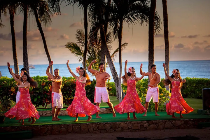 a group of people standing in front of a palm tree