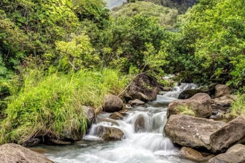 a large waterfall over a rocky cliff