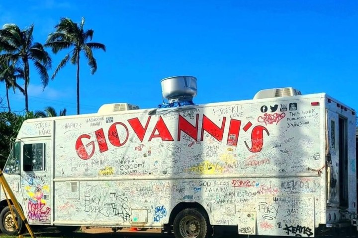 a truck with graffiti on the side of a road