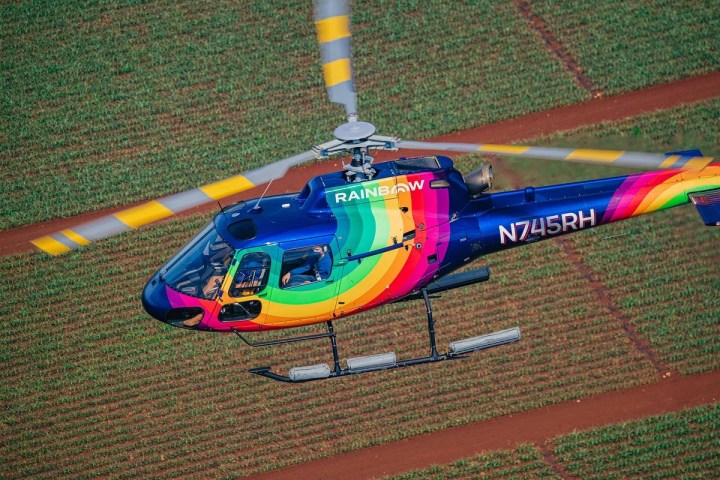 a colorful kite sitting on top of a grass covered field
