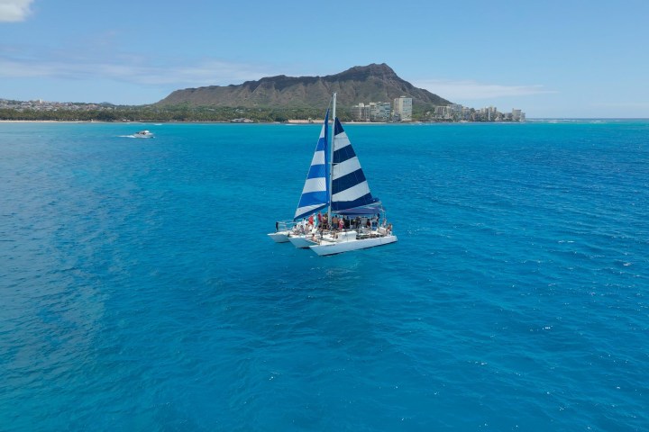 a blue and white boat sitting next to a body of water