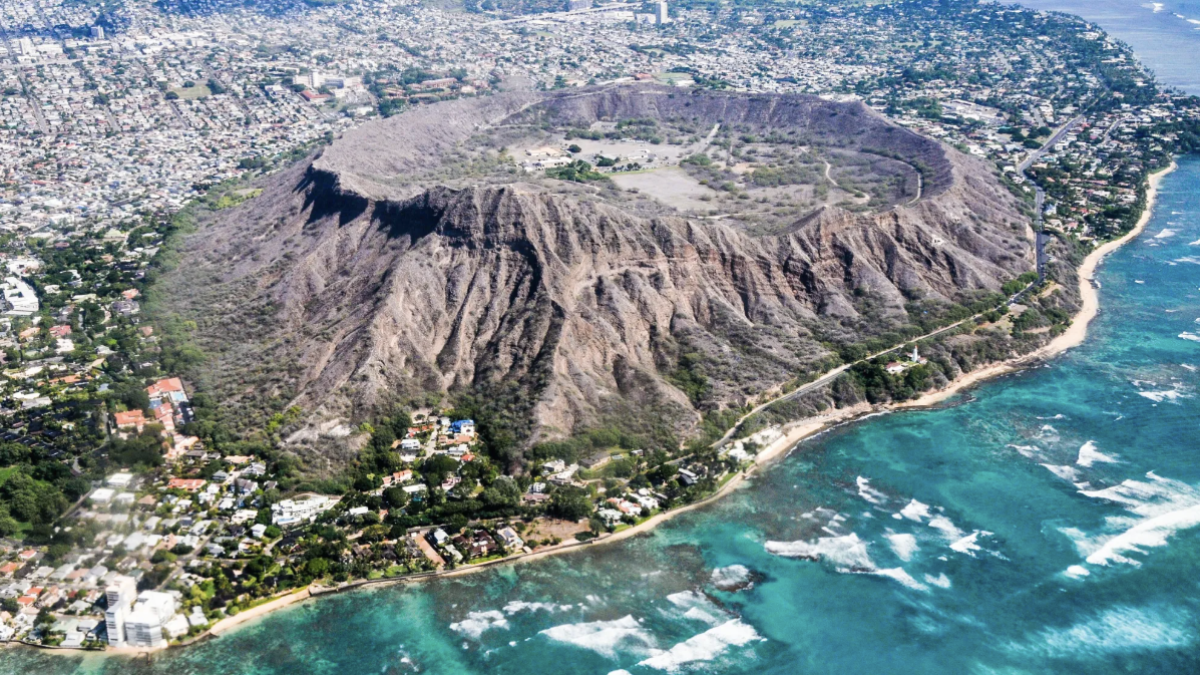 a body of water with Diamond Head in the background