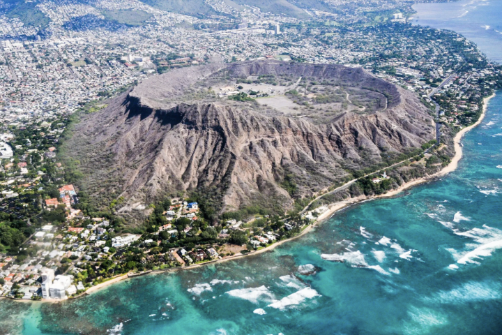 a body of water with Diamond Head in the background