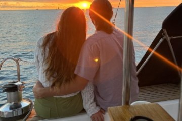 a person sitting at a table in front of a body of water