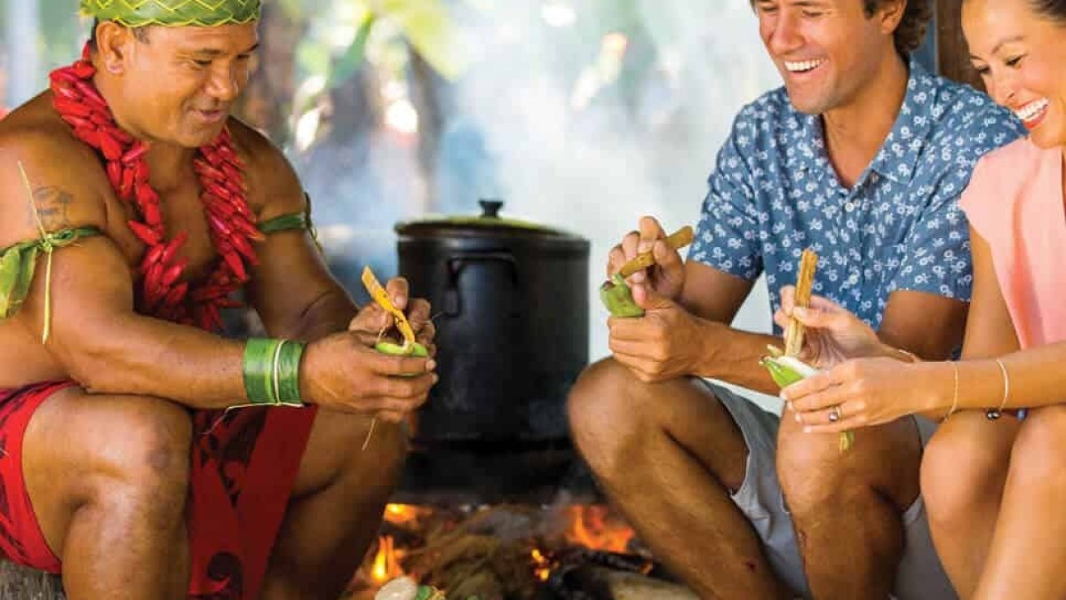 a group of people sitting at a fruit stand