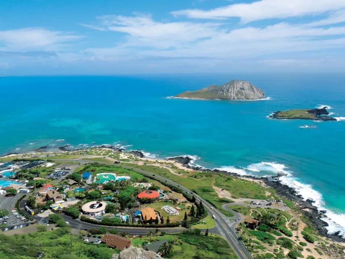 Aerial view of a coastal landscape with an island and clear blue ocean.