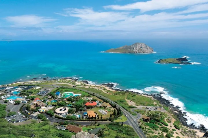 Aerial view of a coastal landscape with an island and clear blue ocean.